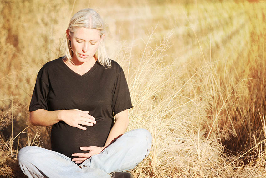 Embarazada sentada en el campo